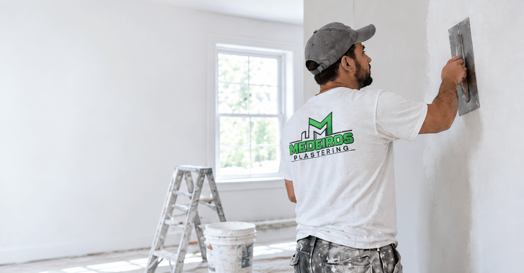 Professional plasterer smoothing a clean white wall